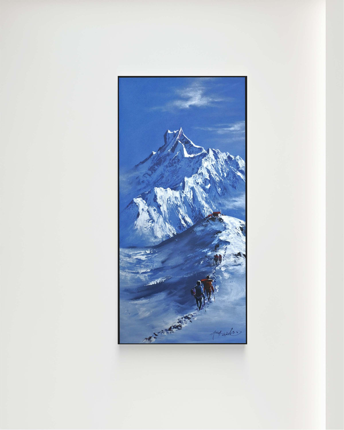 A painting of a snow-covered mountain peak against a vivid blue sky, displayed on a clean white wall.