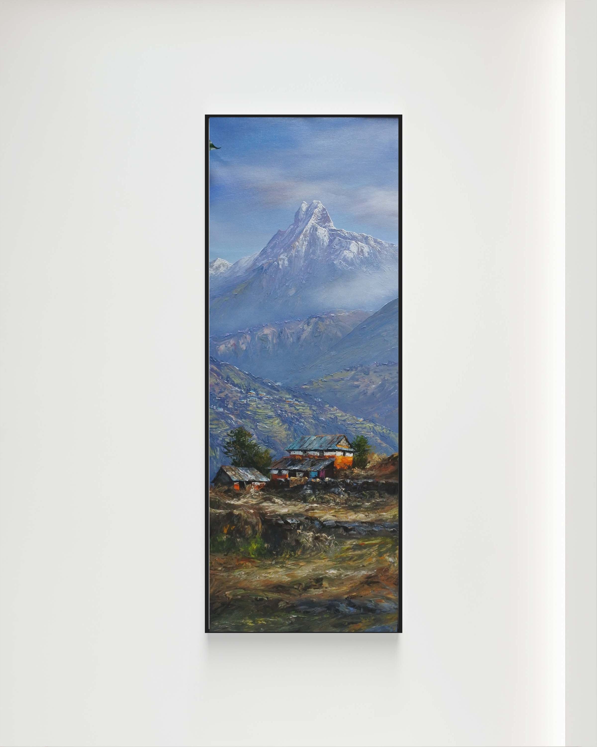 Framed artwork of a mountain landscape with a blue sky on a white wall.