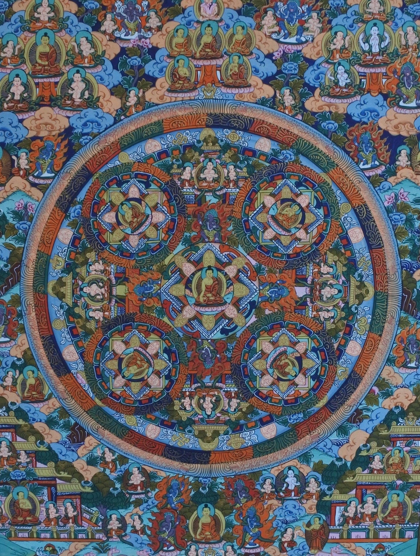 This elegant thangka painting illustrates Buddha in five circles surrounded by several wrathful deities and Bodhisattvas scattered around the mandala. Each Buddha is inside a circle performing a different Mudra (hand gesture).